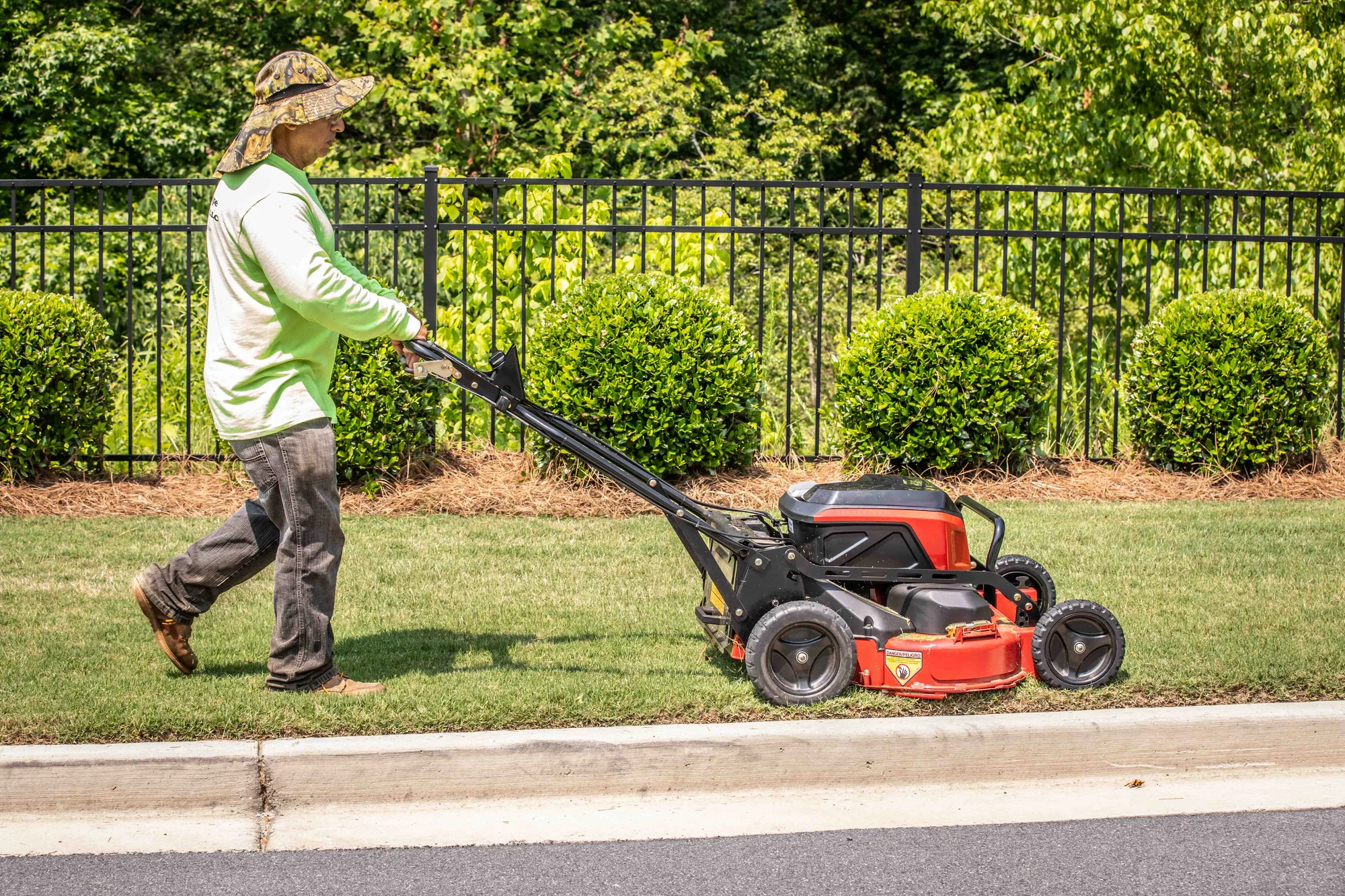 Exmark Commercial 30 V Series Walk Behind Lawn Mower ECV060B0230010 Exmark Commercial 30 V Series Walk Behind Lawn Mower Ecv060B0230010 Landscaper Mowing Curb Edge Along Metal Fence product image