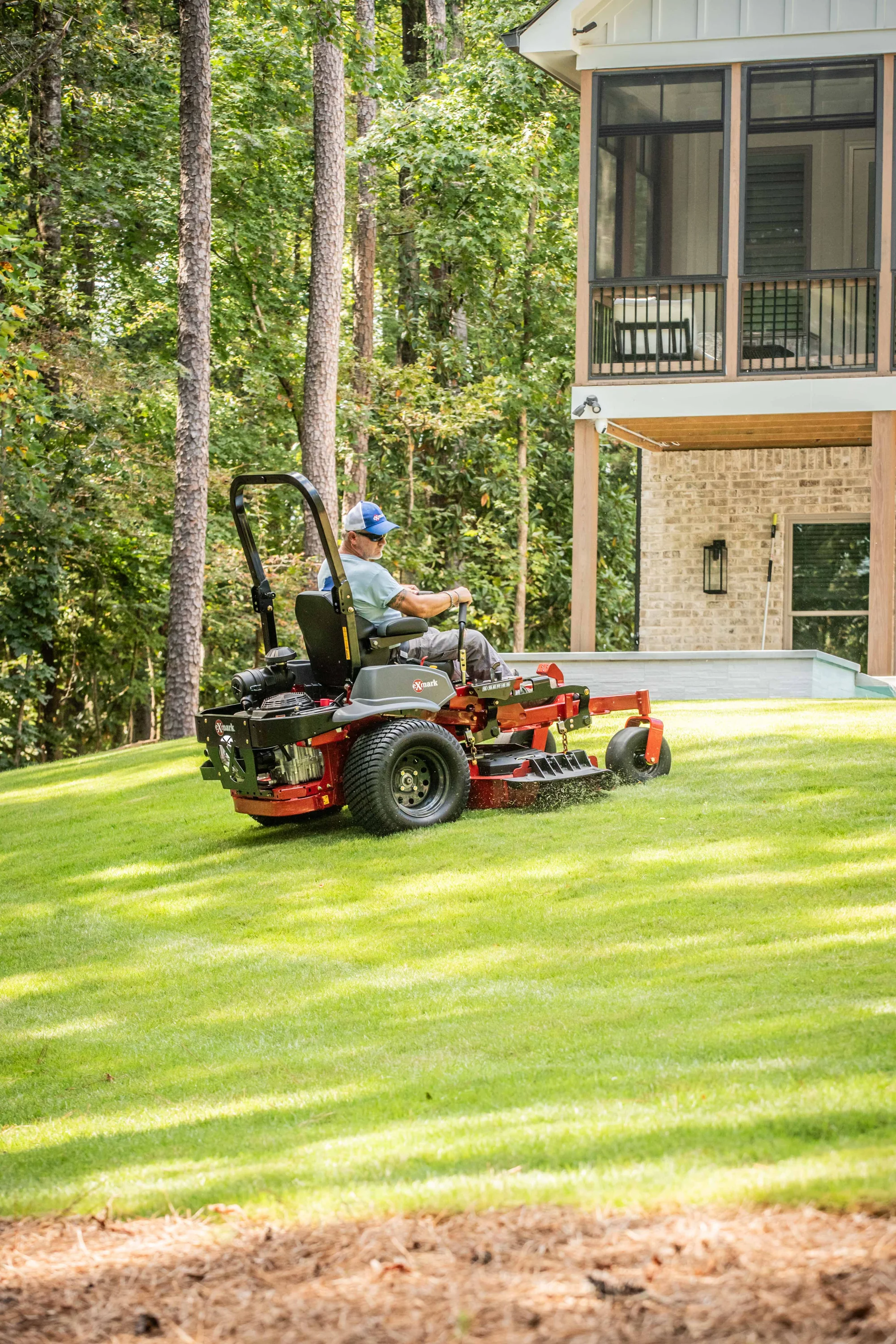 Exmark Lazer Z S Series Zero Turn Rider Lrs749Akc524A2 Man Mowing Lawn Uphill 1 product image