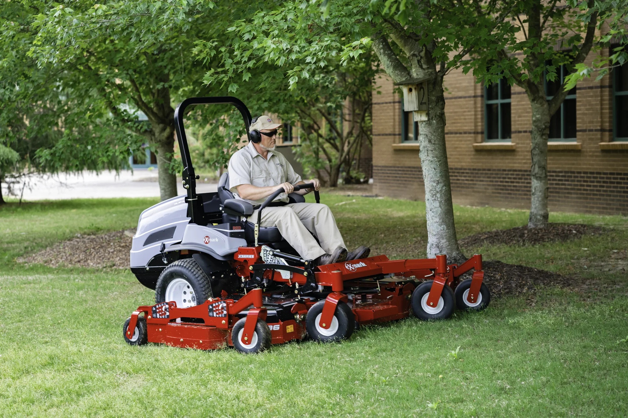 Exmark Lazer Z X Series Zero Turn Rider LZX980EKC606R1 Exmark Lazer Z X Series Zero Turn Rider Lzx980Ekc606R1 Man Mowing Around Trees product image