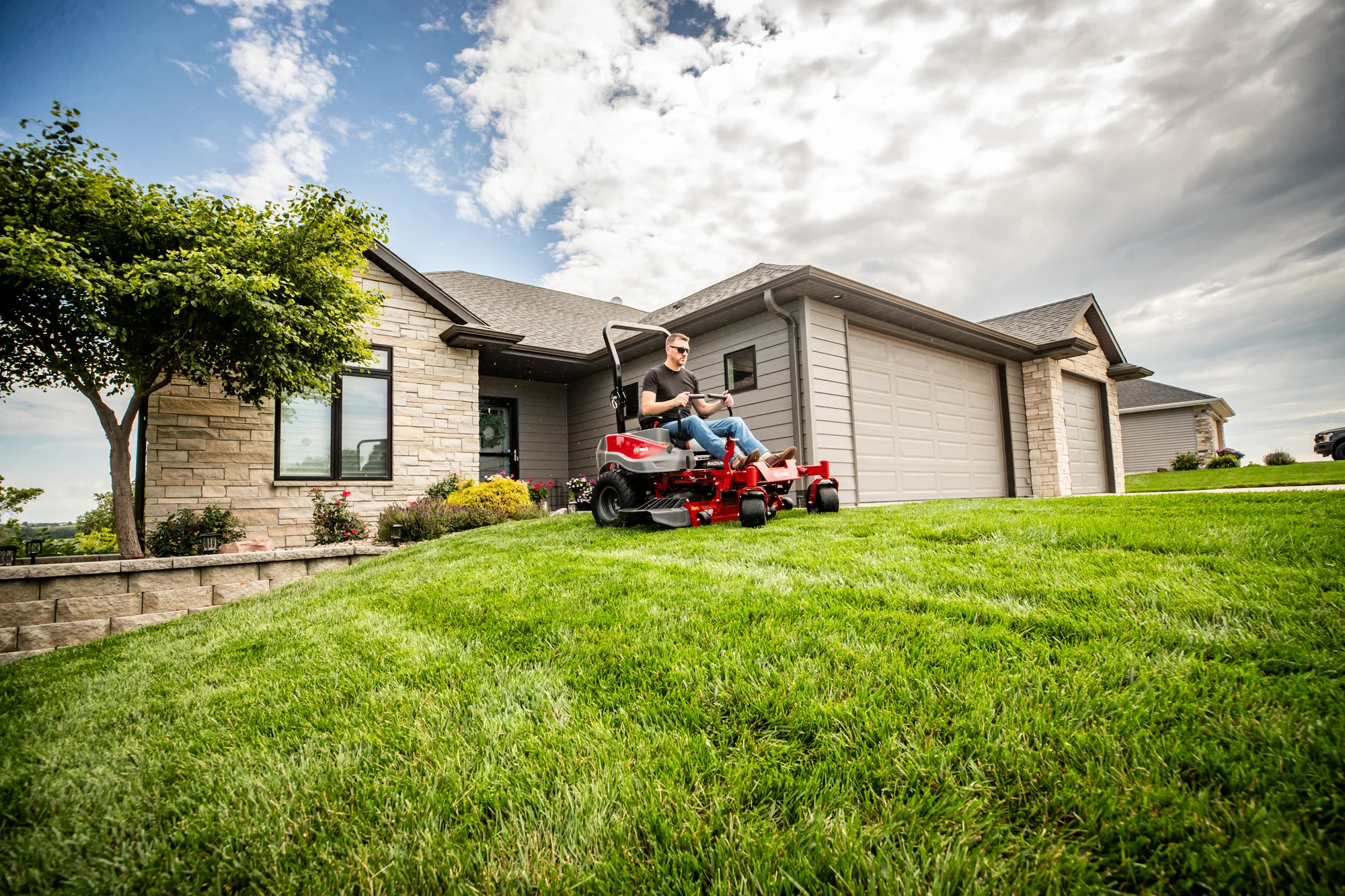 Exmark Radius E Series Zero Turn Rider Rde691Gka48200 Man Mowing Lawn House Distant product image