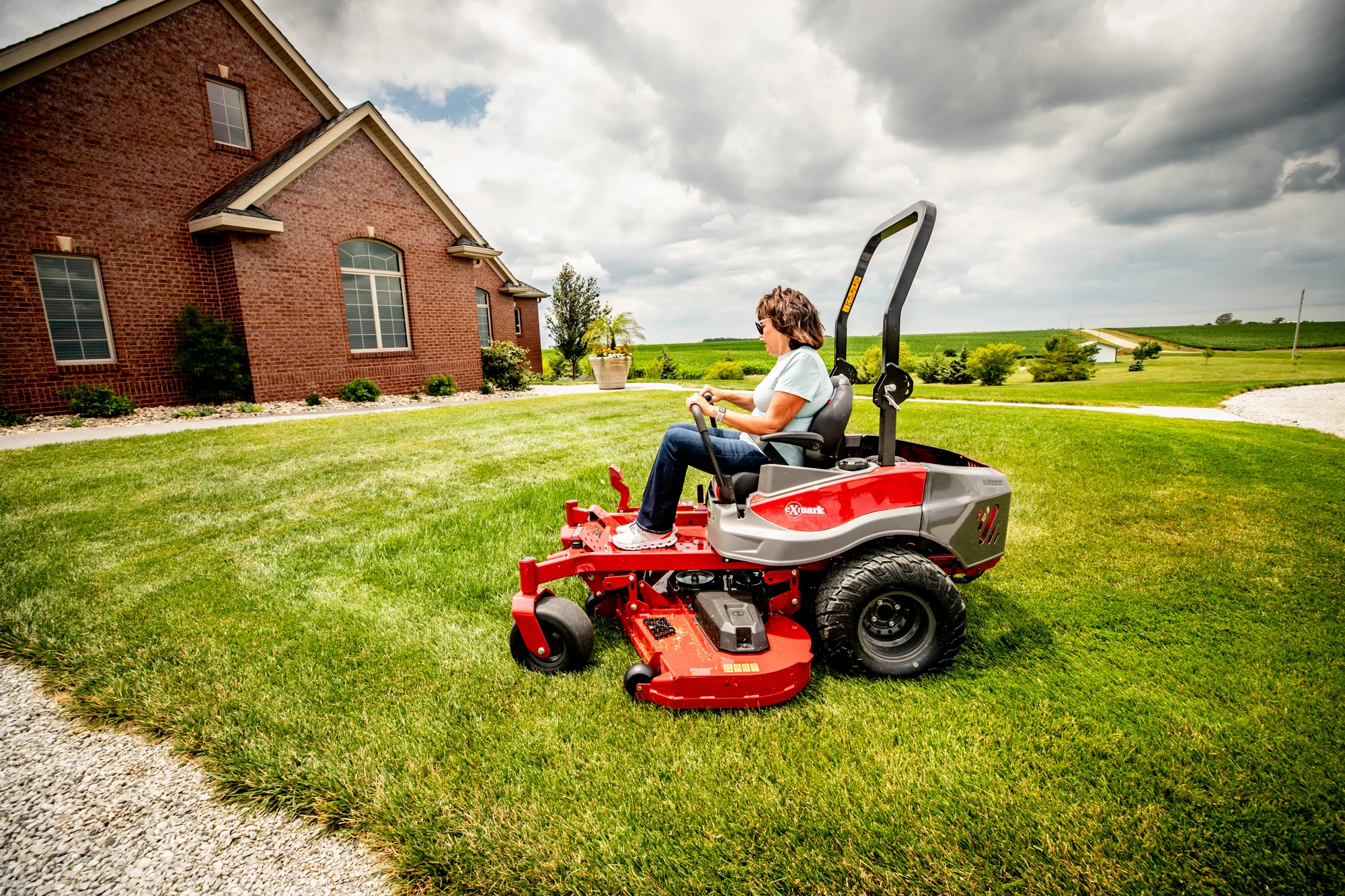 Exmark Radius E Series Zero Turn Rider RDE691GKA48200 Exmark Radius E Series Zero Turn Rider Rde691Gka48200 Woman Mowing Grass Wide Angle product image