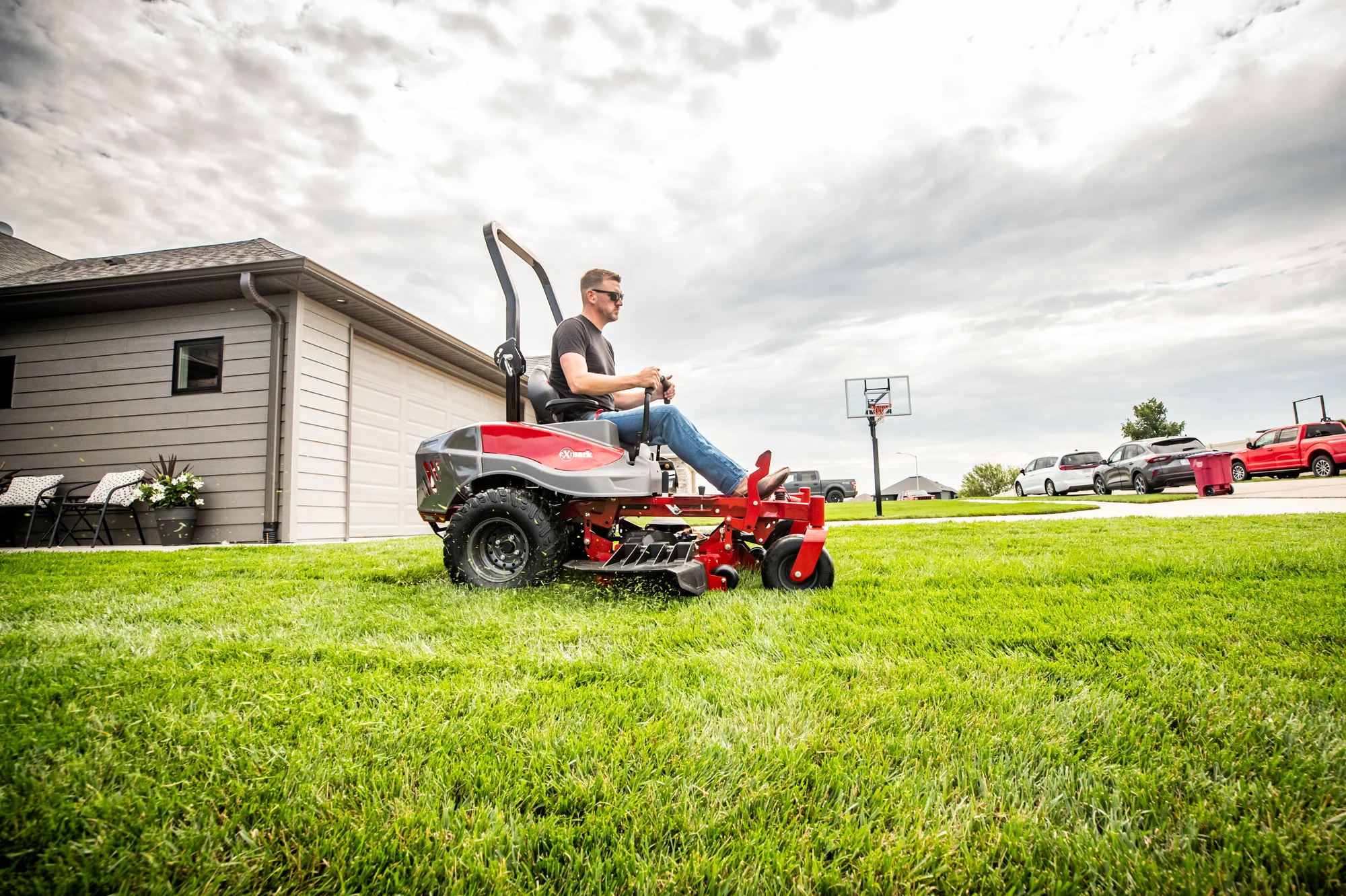 Exmark Radius E Series Zero Turn Rider RDE691GKA54200 Exmark Radius E Series Zero Turn Rider Rde691Gka54200 Man Mowing Lawn House Wide Angle product image