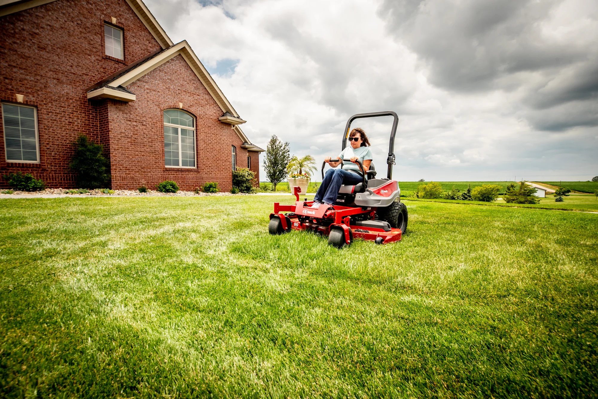 Exmark Radius E Series Zero Turn Rider Rde691Gka54200 Woman On Mower Wide Angle Distant product image