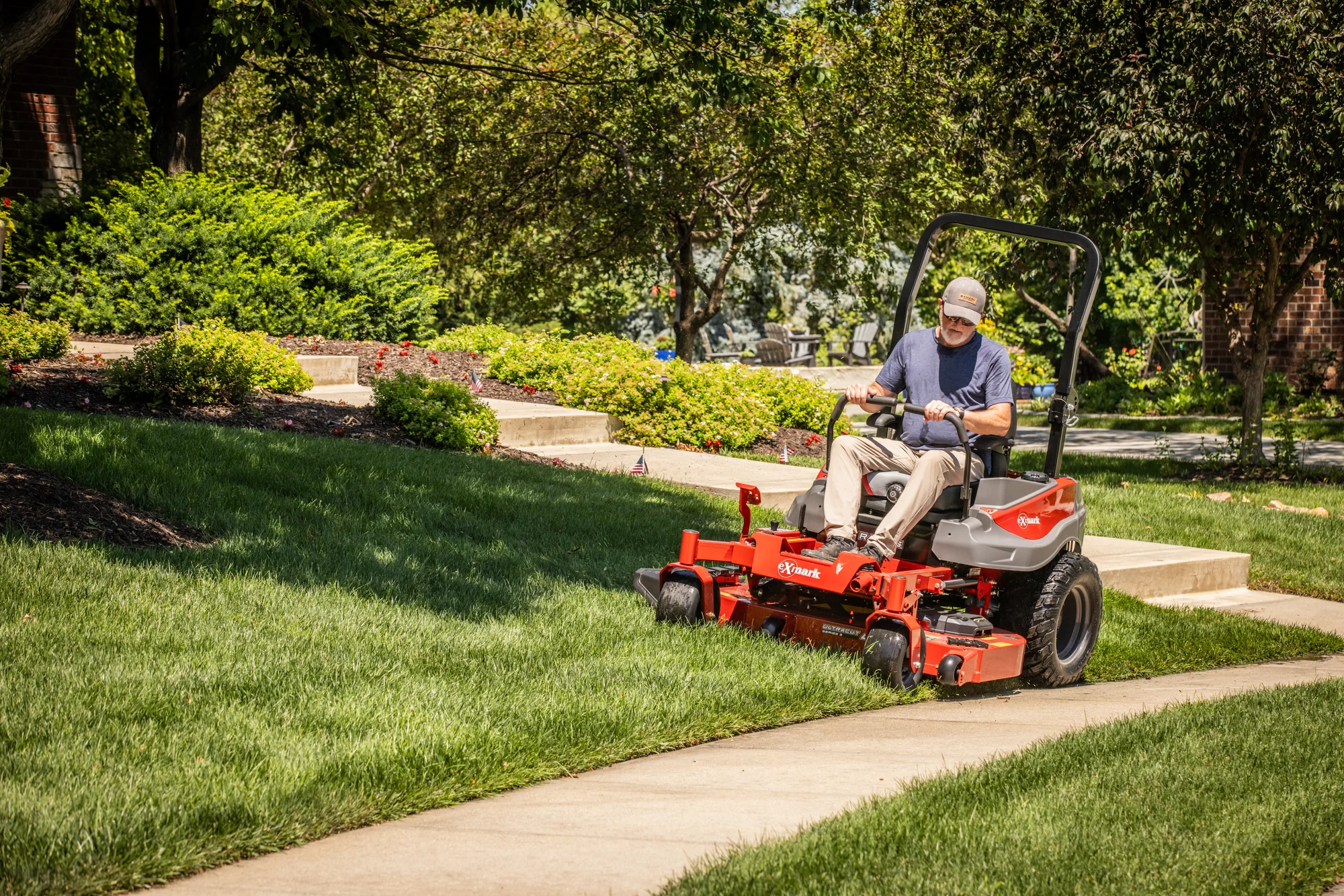 Exmark Radius S Series Zero Turn Rider Rds691Gka523A3 Man Cutting Grass Sidewalk product image