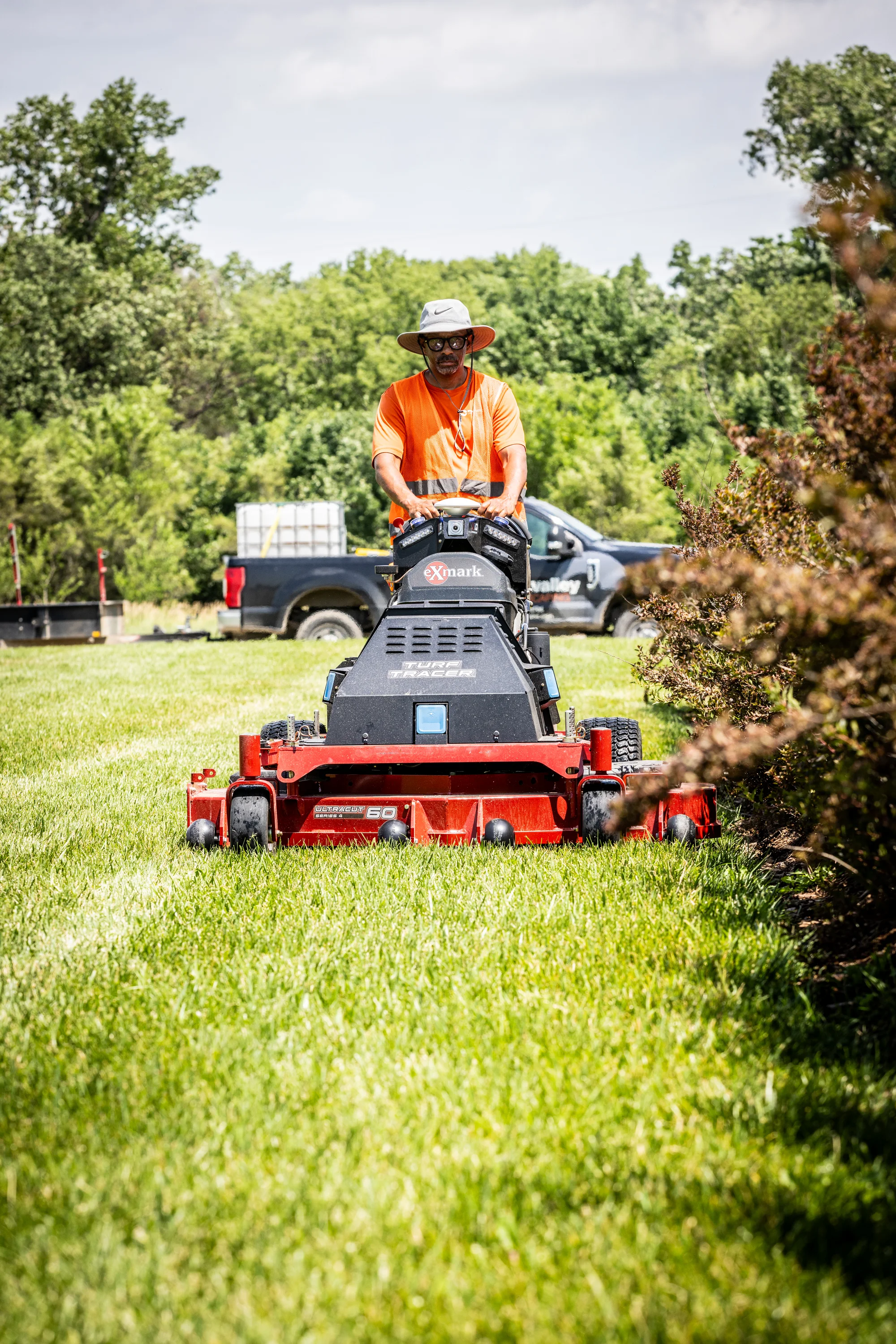 Exmark Turf Tracer Autonomous Series Lawn Mower TTA749AKC604N0 Exmark Turf Tracer Autonomous Series Walk Behind Lawn Mower Tta749Akc604N0 Man Mowing Bushes product image