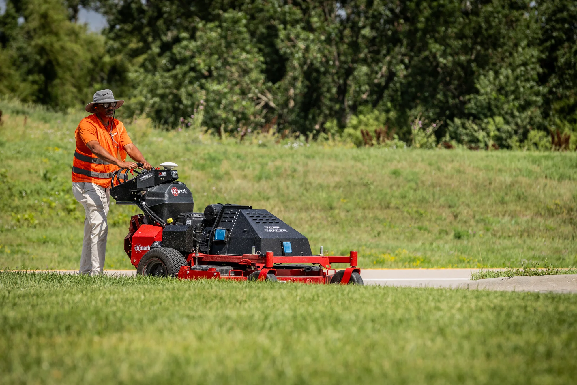 Exmark Turf Tracer Autonomous Series Walk Behind Lawn Mower Tta749Akc604N0 Man Mowing Driveway product image