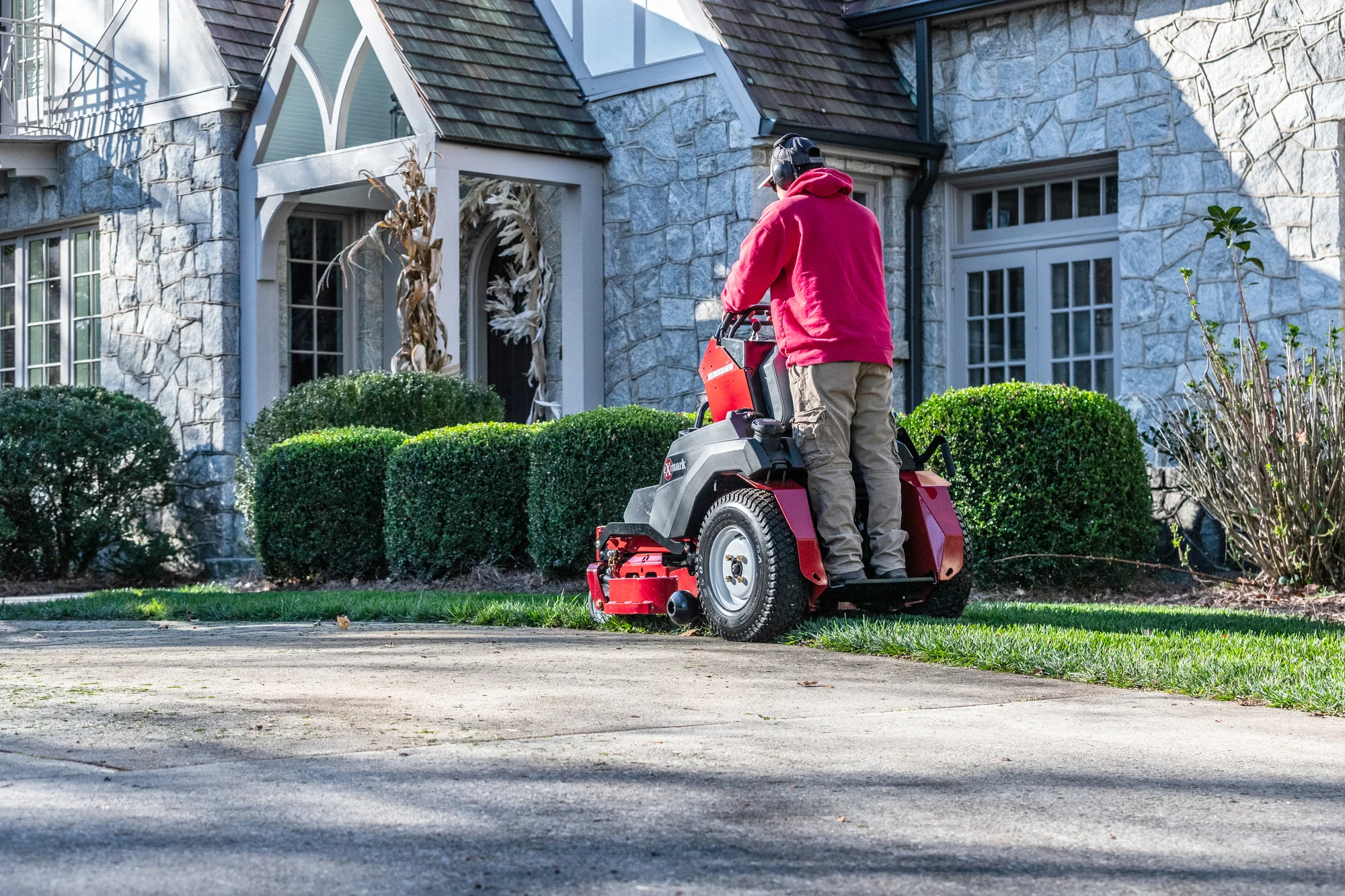 Exmark Vertex E Series Stand-On Lawn Mower VXE600GKA32300 Exmark Vertex E Series Stand On Lawn Mower Vxe600Gka32300 Man Mowing Driveway Back View product image