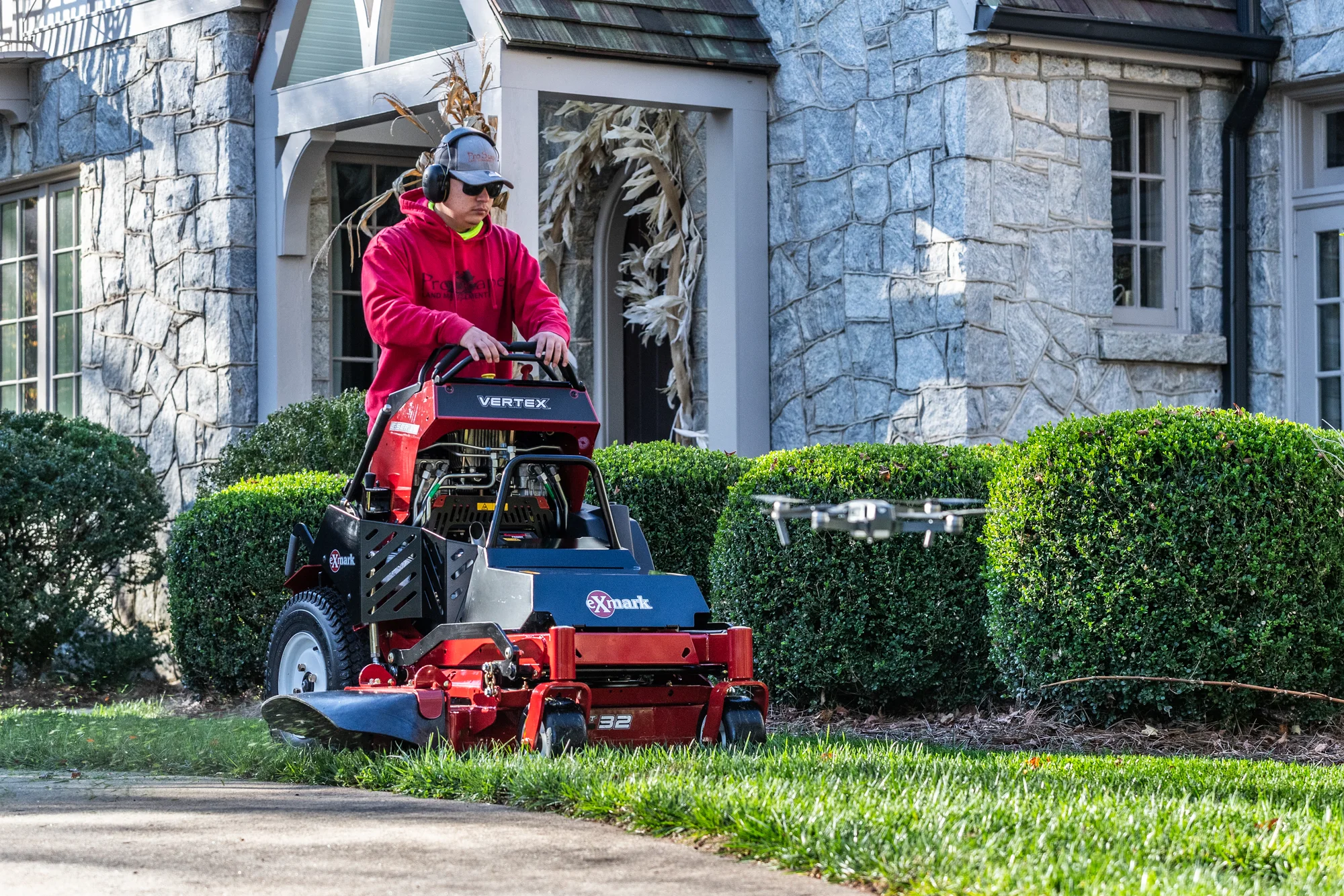 Exmark Vertex E Series Stand-On Lawn Mower VXE600GKA32300 Exmark Vertex E Series Stand On Lawn Mower Vxe600Gka32300 Man Mowing Driveway Front View product image