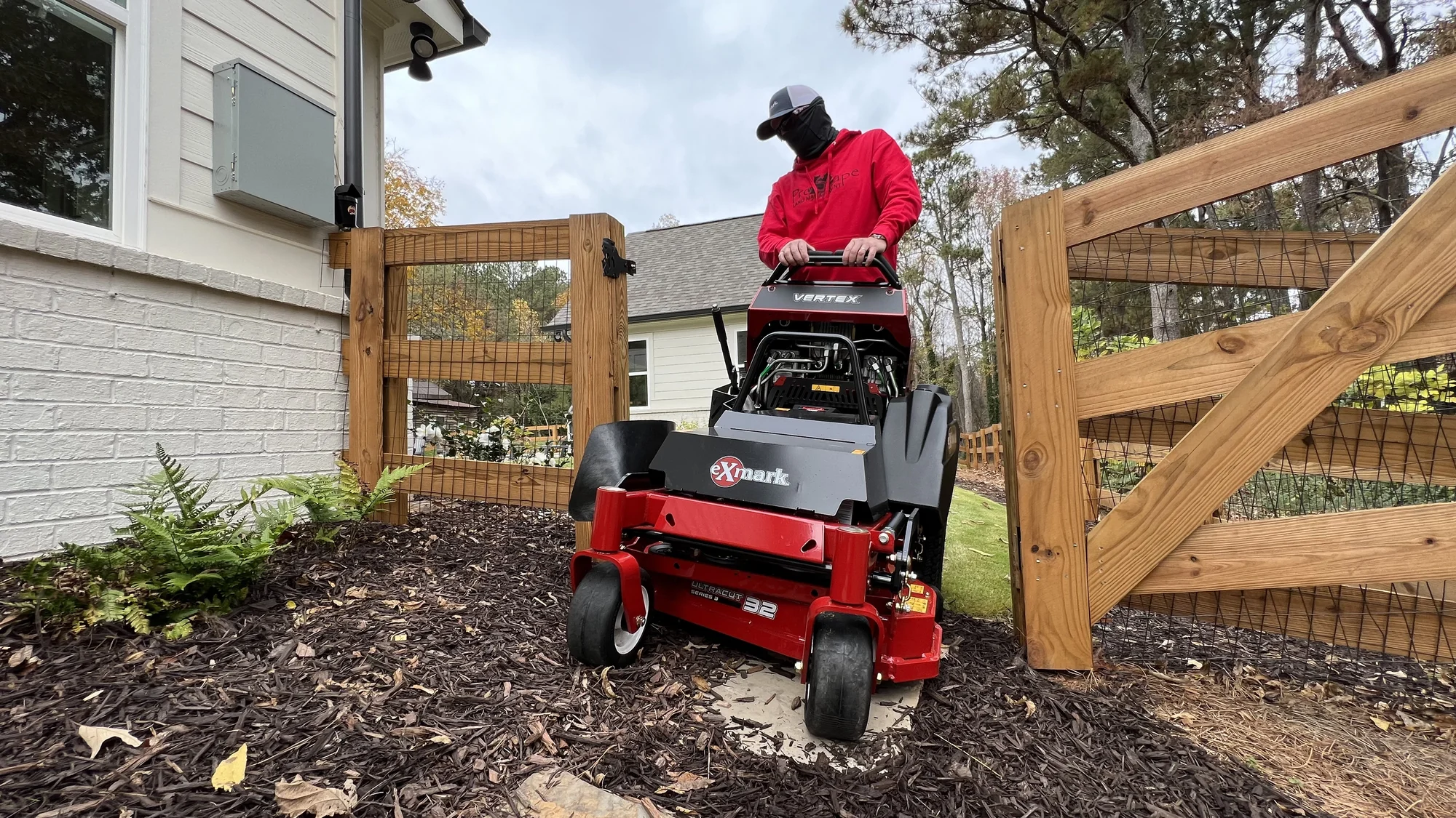 Exmark Vertex E Series Stand On Lawn Mower Vxe600Gka36300 Landscaper Mowing Near Fence Wide Angle product image
