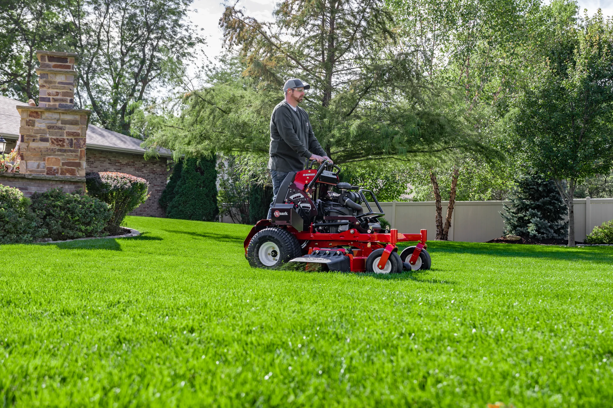 Exmark Vertex S Series Stand On Lawn Mower Vxs730Gka48400 Man Mowing Lawn Near House product image