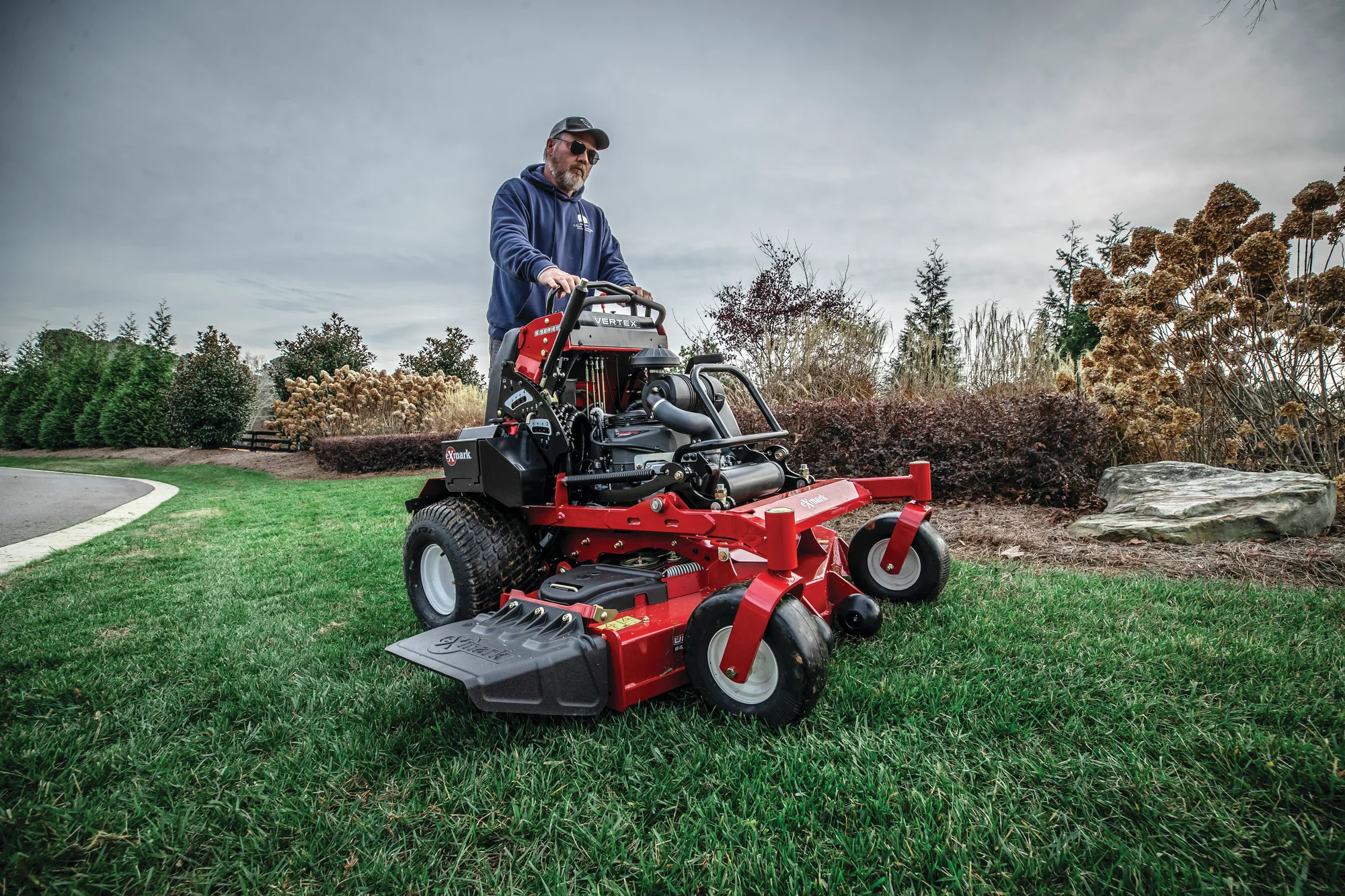 Exmark Vertex S Series Stand-On Lawn Mower VXS730GKA52400 Exmark Vertex S Series Stand On Lawn Mower Vxs730Gka52400 Man Mowing Lawn Wide Angle product image