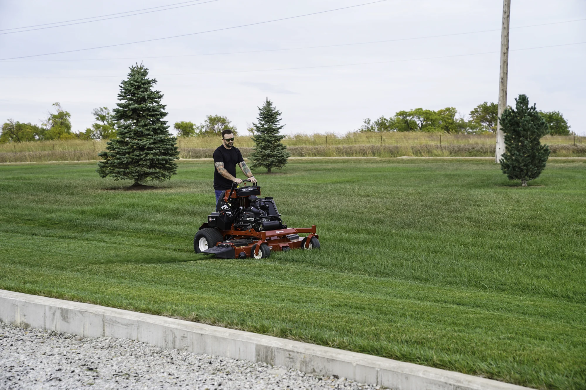 Exmark Vertex S Series Stand On Lawn Mower Vxs730Gka60400 Man Mowing Grass Near Driveway product image