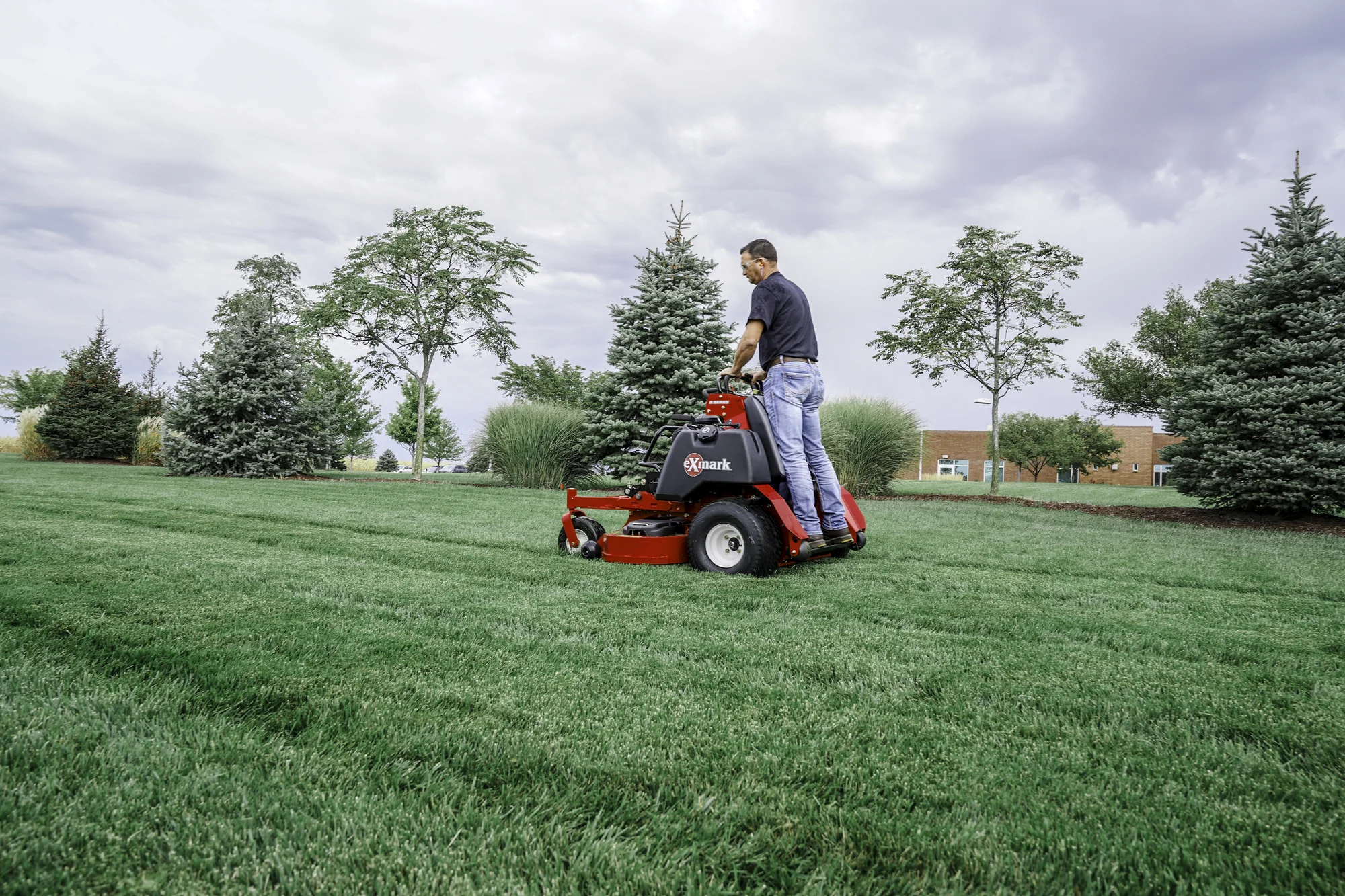 Exmark Vertex S Series Stand On Lawn Mower Vxs740Ekc52400 Man Mowing Lawn Angle View Right product image