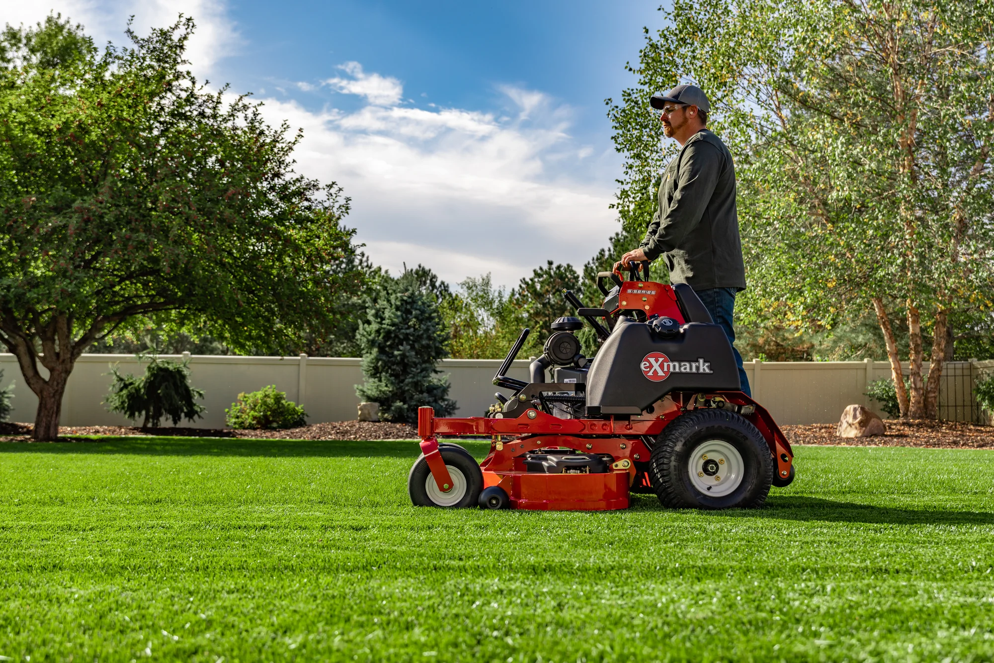 Exmark Vertex S Series Stand-On Lawn Mower VXS740EKC60400 Exmark Vertex S Series Stand On Lawn Mower Vxs740Ekc60400 Man Mowing Lawn Side View product image