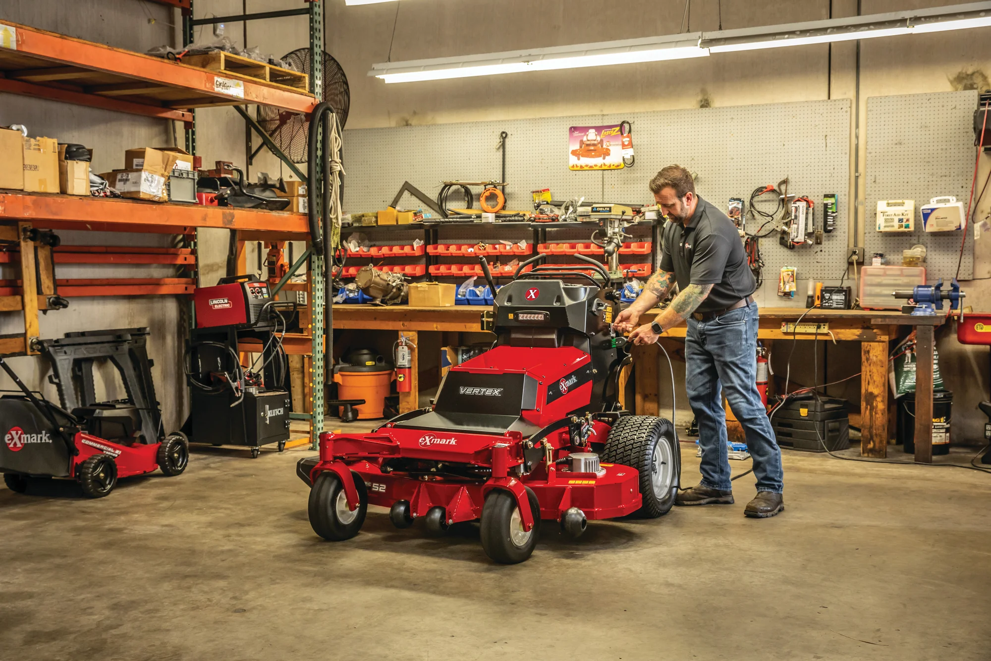 Exmark Vertex V Series Stand On Lawn Mower Vxv060B1852A00 Man And Mower In Garage product image