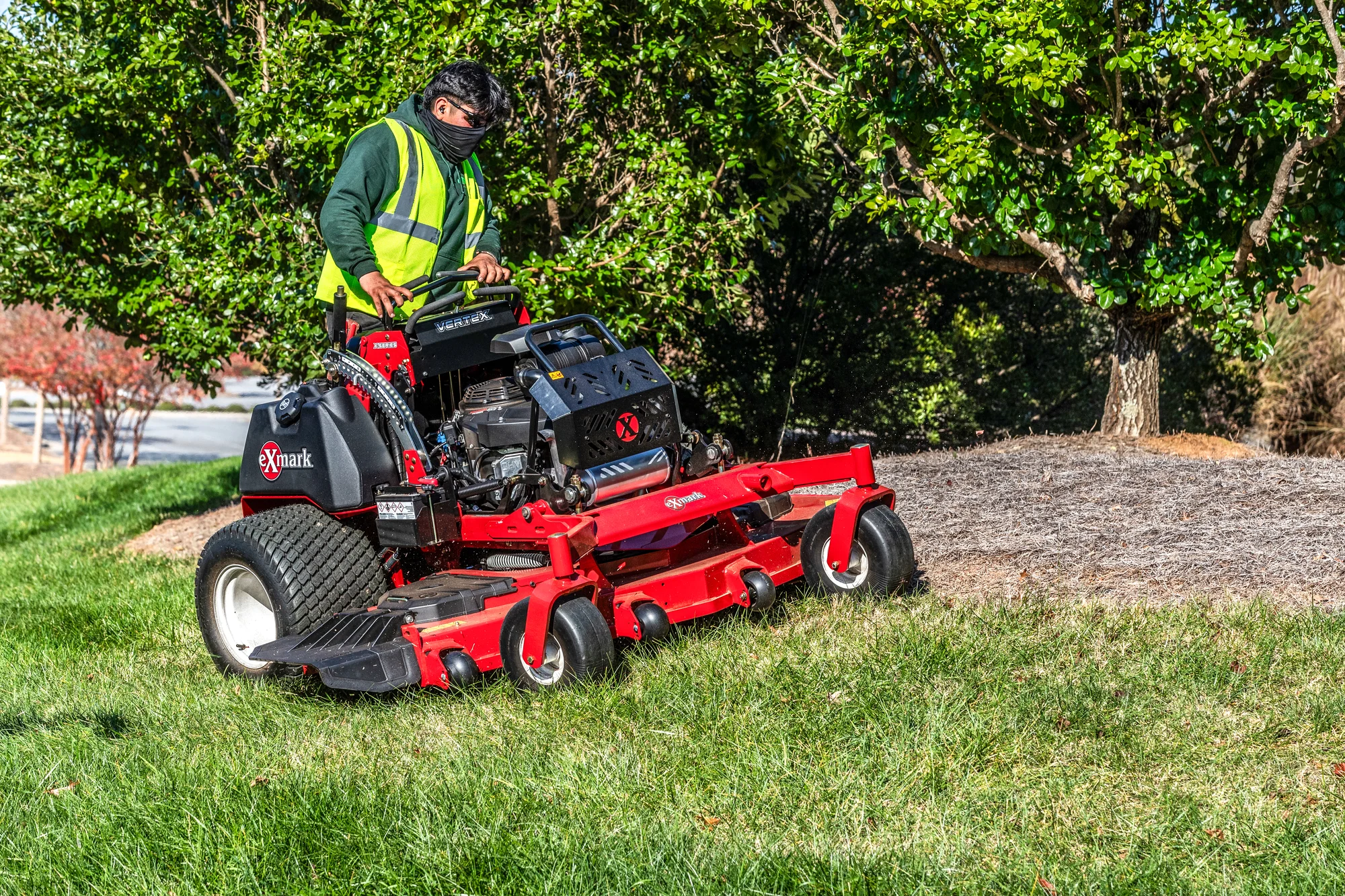 Exmark Vertex X Series Stand On Lawn Mower Vxx999Eka72600 Man With Mask Mowing Up Hill product image