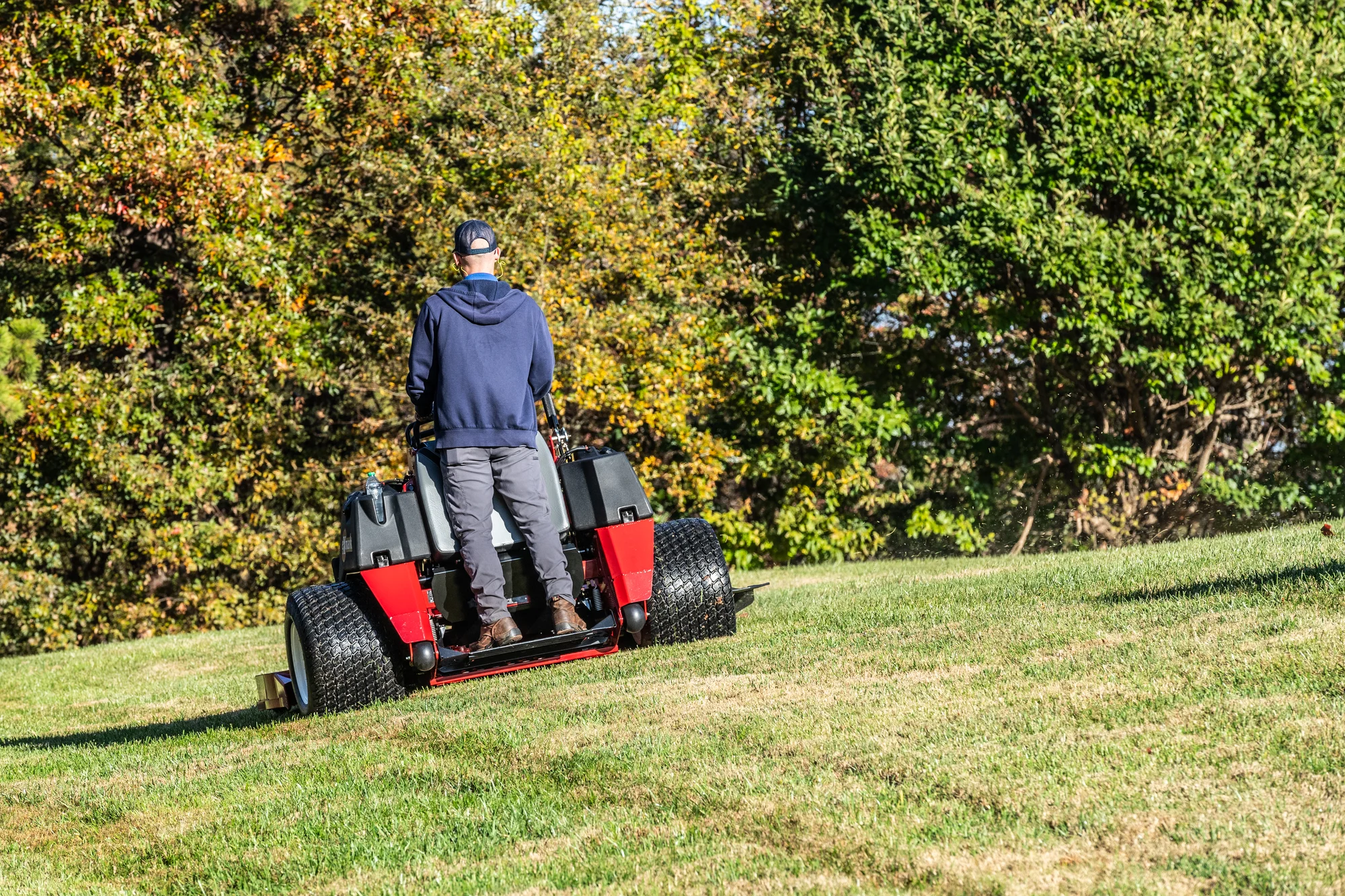 Exmark Vertex X Series Stand-On Lawn Mower VXX999GKA60600 Exmark Vertex X Series Stand On Lawn Mower Vxx999Gka60600 Back View Man Mowing Grass product image