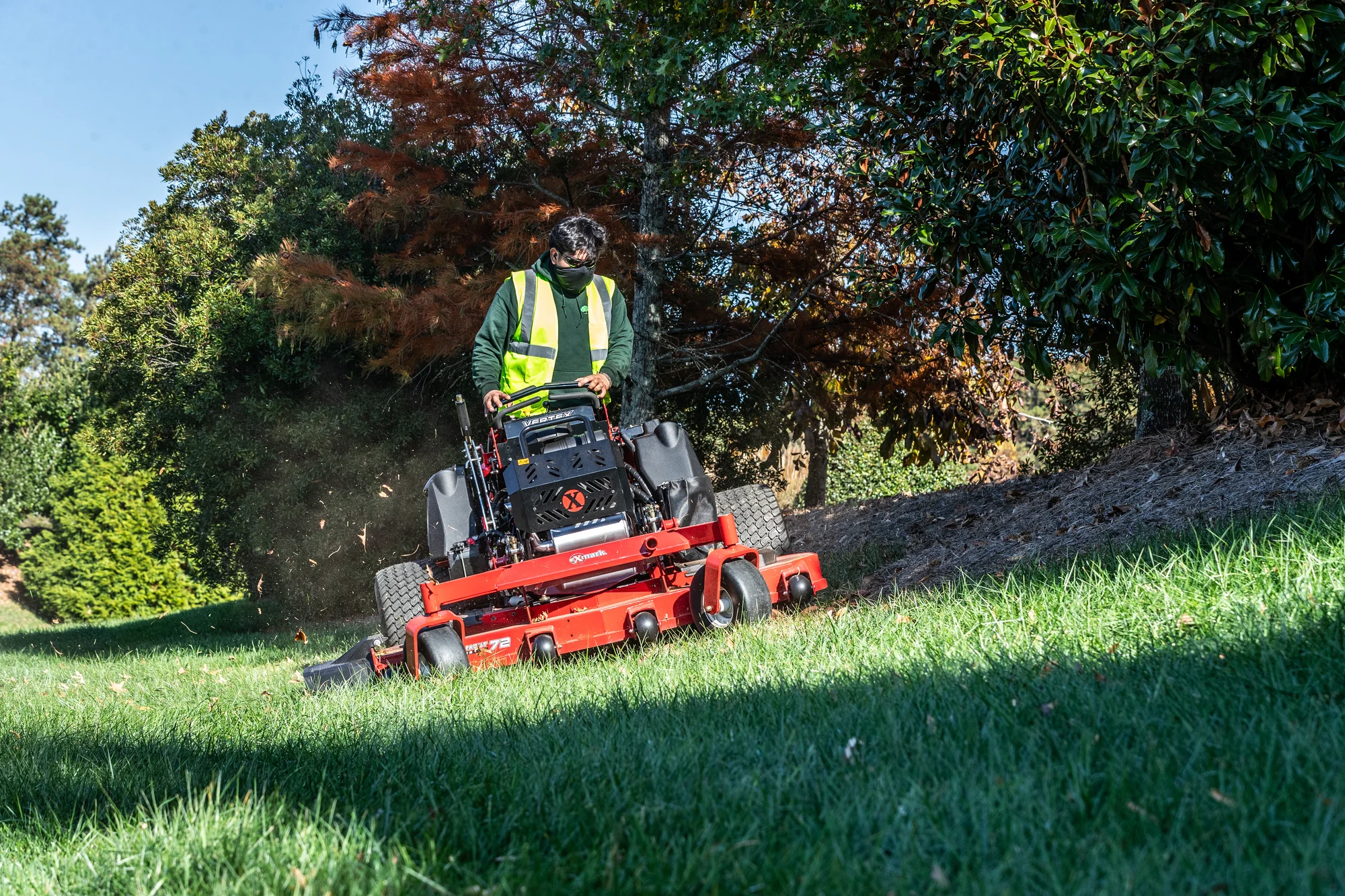 Exmark Vertex X Series Stand On Lawn Mower Vxx999Gka60600 Man With Mask Mowing Hill Shade product image