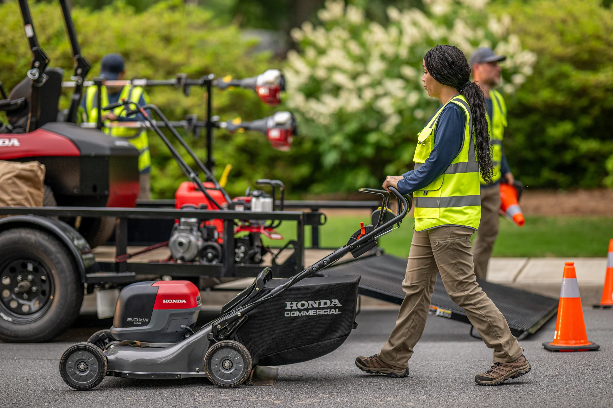 Honda Hrc Be Battery Powered Walk Behind Lawn Mower Hrc216Exa6 Side View Right Woman On Sidewalk product image