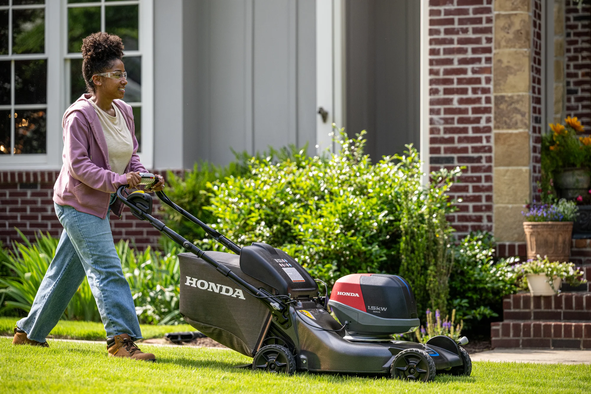 Honda Hrn Bv Battery Powered Walk Behind Lawn Mower Hrn216Vka4 Side View Left Woman Cutting Lawn product image