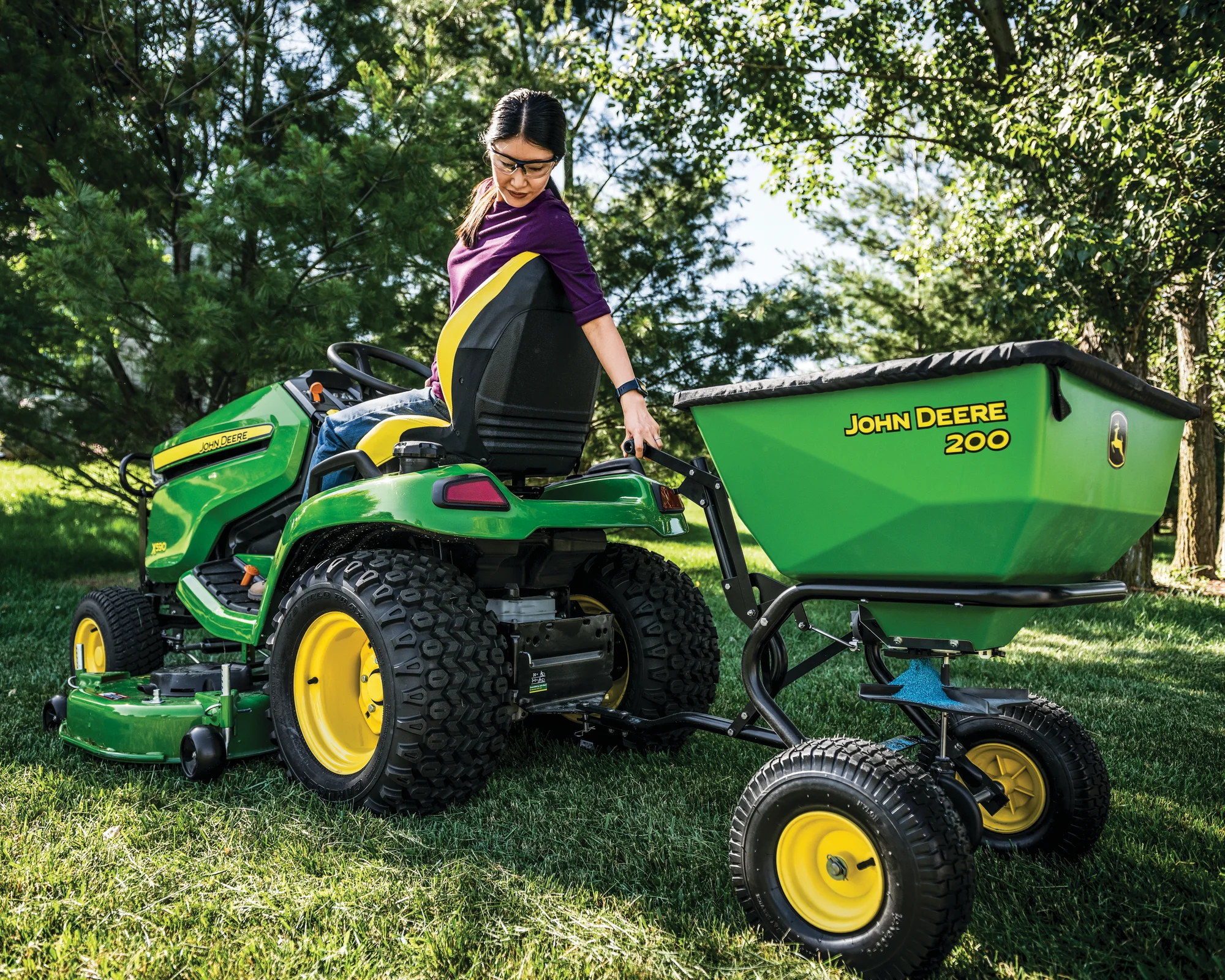 John Deere Select X500 Series Lawn Tractor X590 54 Back View Right Woman Towing Spreader product image