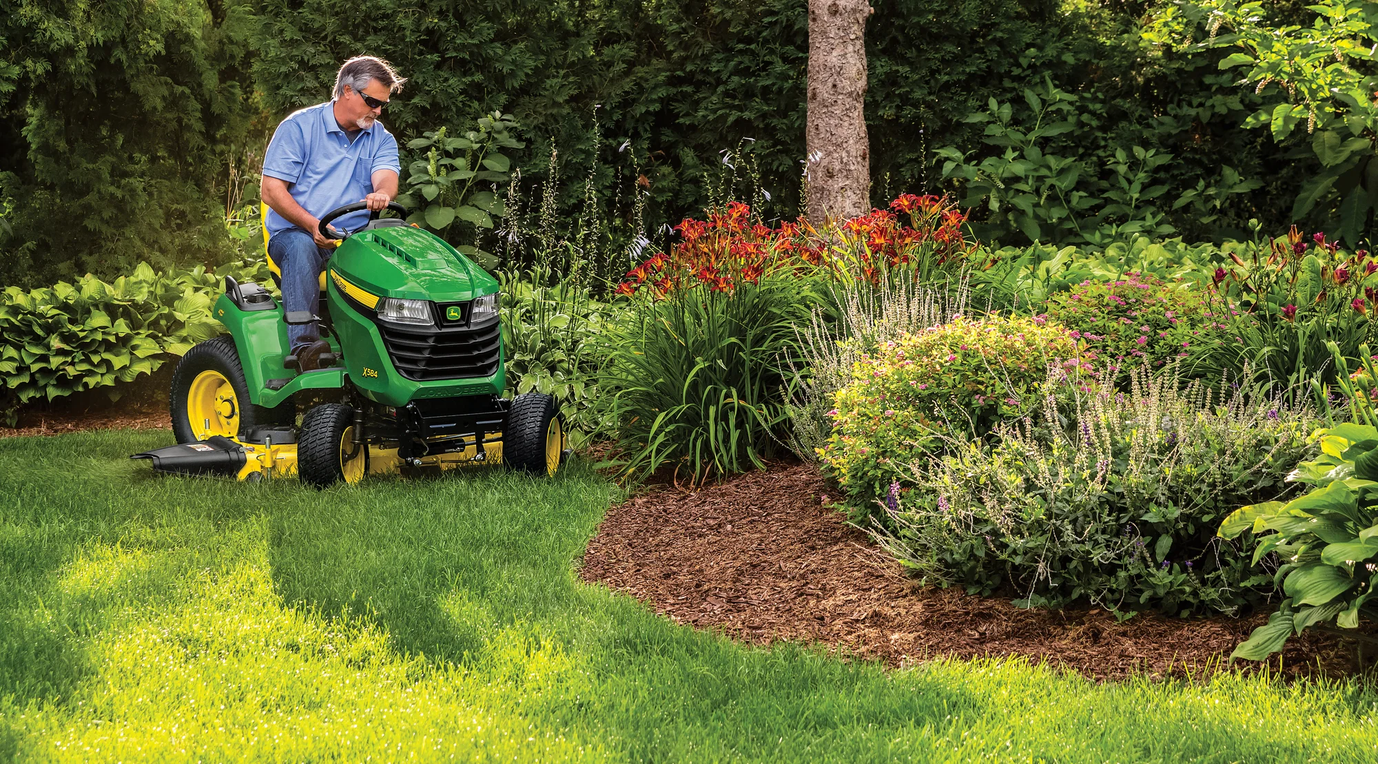 John Deere X500 Select Series Lawn Tractor X584 Mowing Around Garden Bed product image