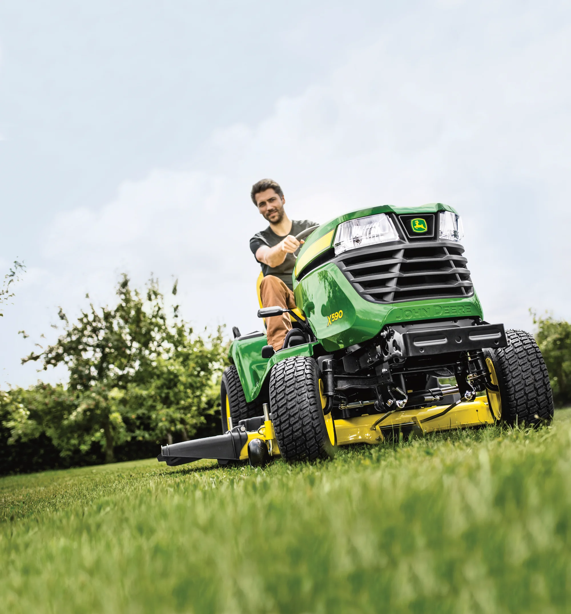 John Deere X500 Select Series Lawn Tractor X590 Man Mowing Close Up Tire Left View product image