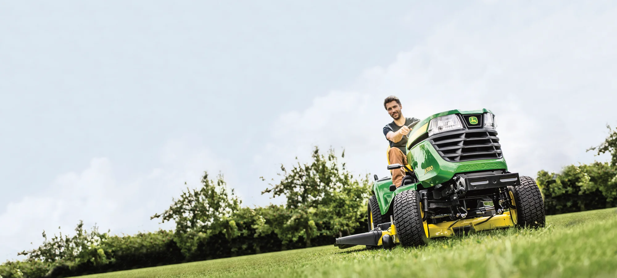 John Deere X500 Select Series Lawn Tractor X590 Man Mowing Close Up Tire Wide Angle product image