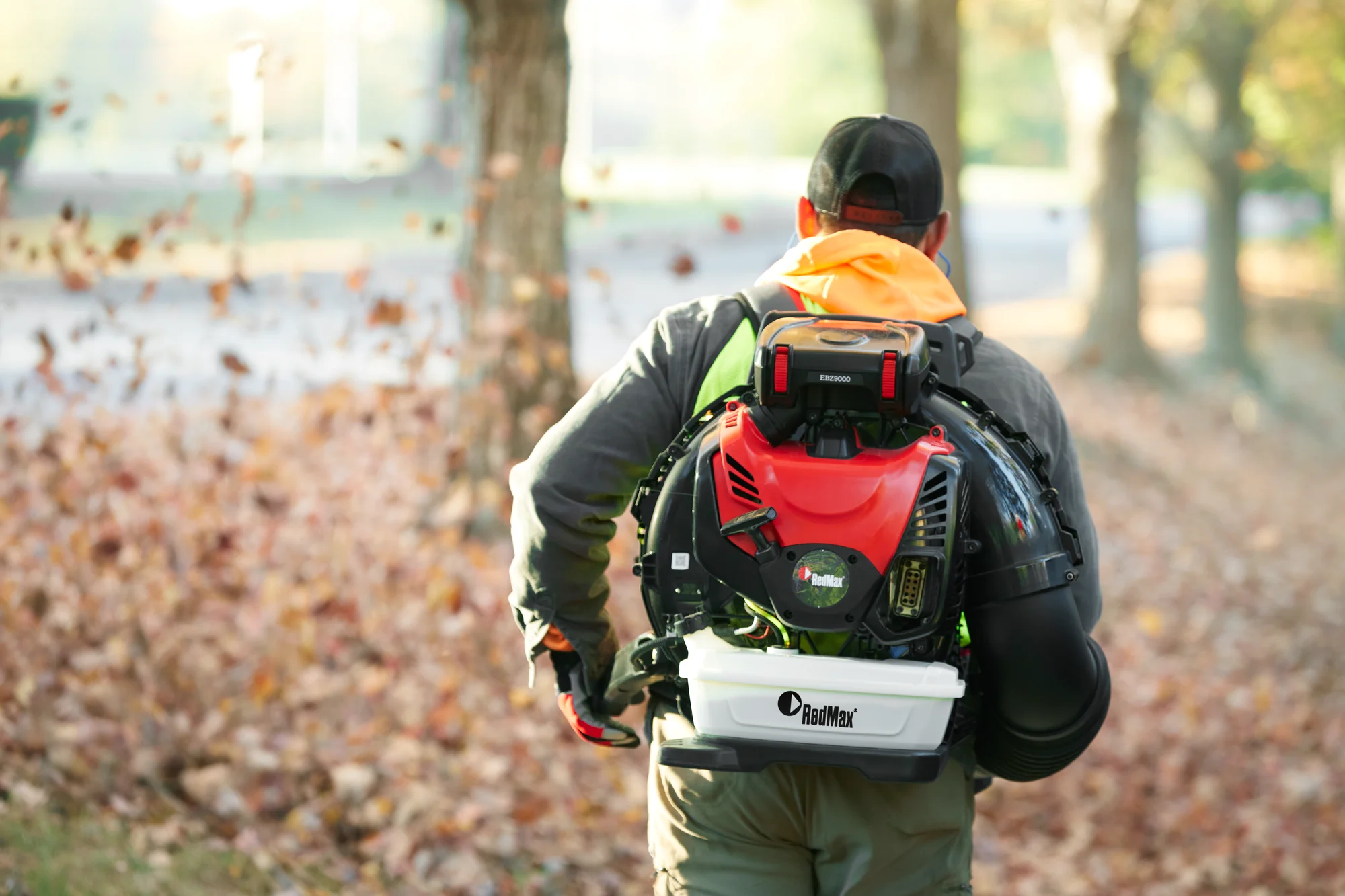 Redmax Ebz Series Backpack Blower Ebz9000 Lifestyle Back Full Product View Closeup Man Blowing Leaves product image