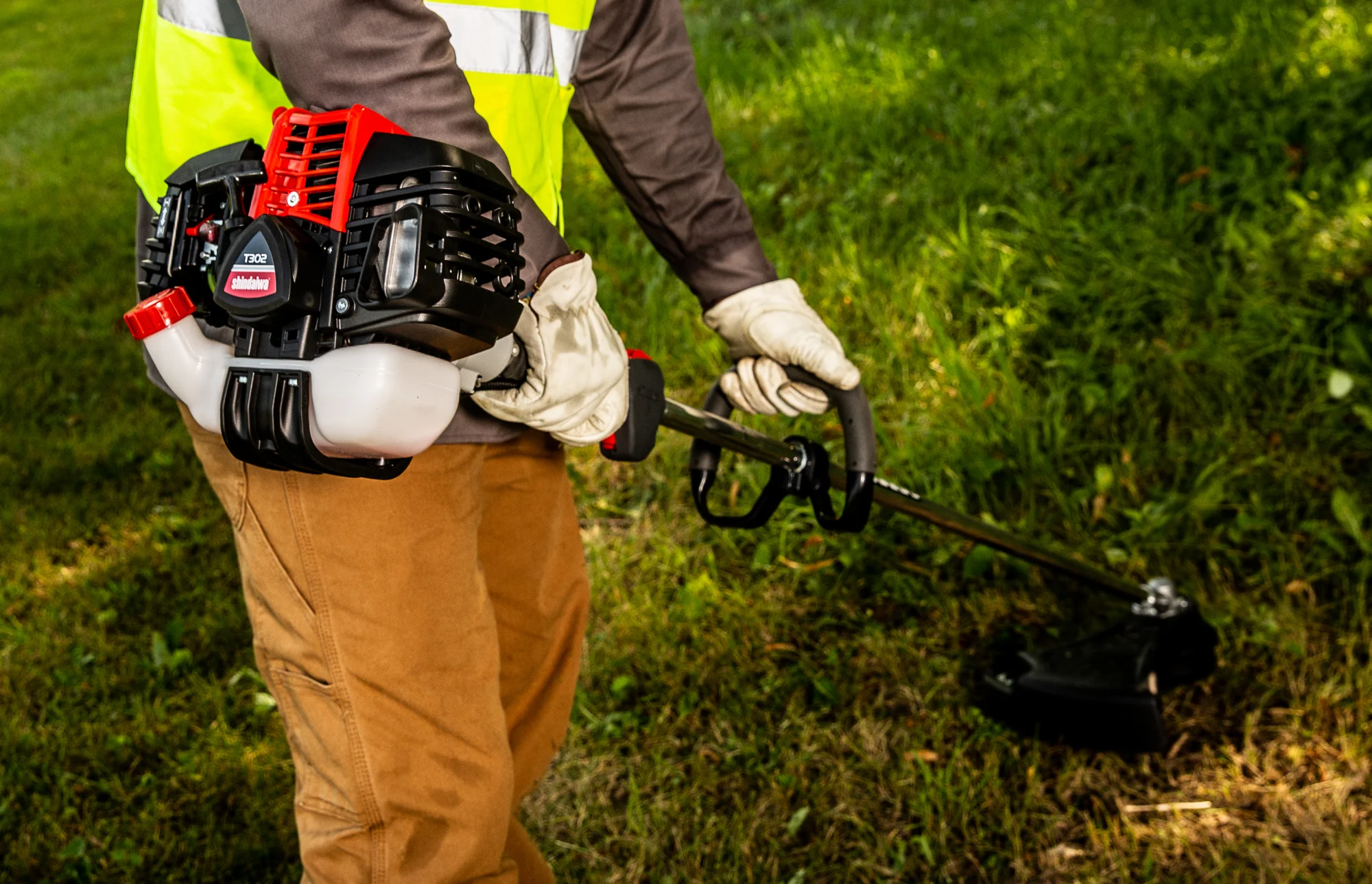 Shindaiwa T Series Trimmer T302 Lifestyle Closeup Power Head Man Trimming Grass product image