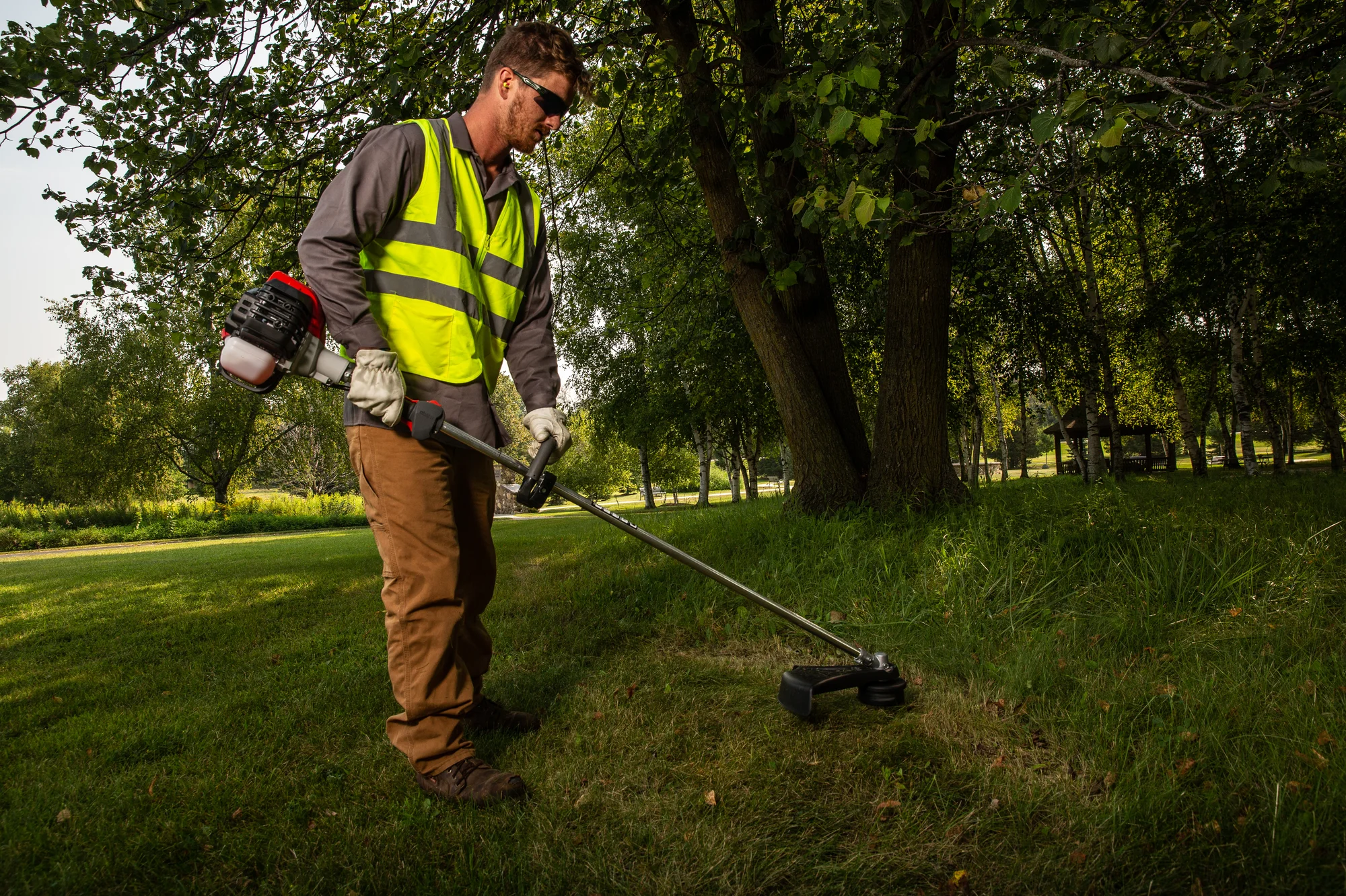 Shindaiwa T Series Trimmer T302 Lifestyle Wide Shot Right Man Trimming Grass product image