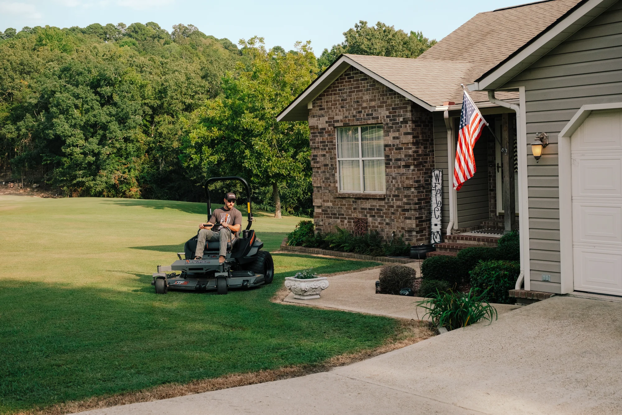 Spartan RZ-HD Zero Turn Rider RSZL115427CXI Spartan Rz Hd Zero Turn Rider Rszl115427Cxi Man Cutting Grass Sidewalk product image