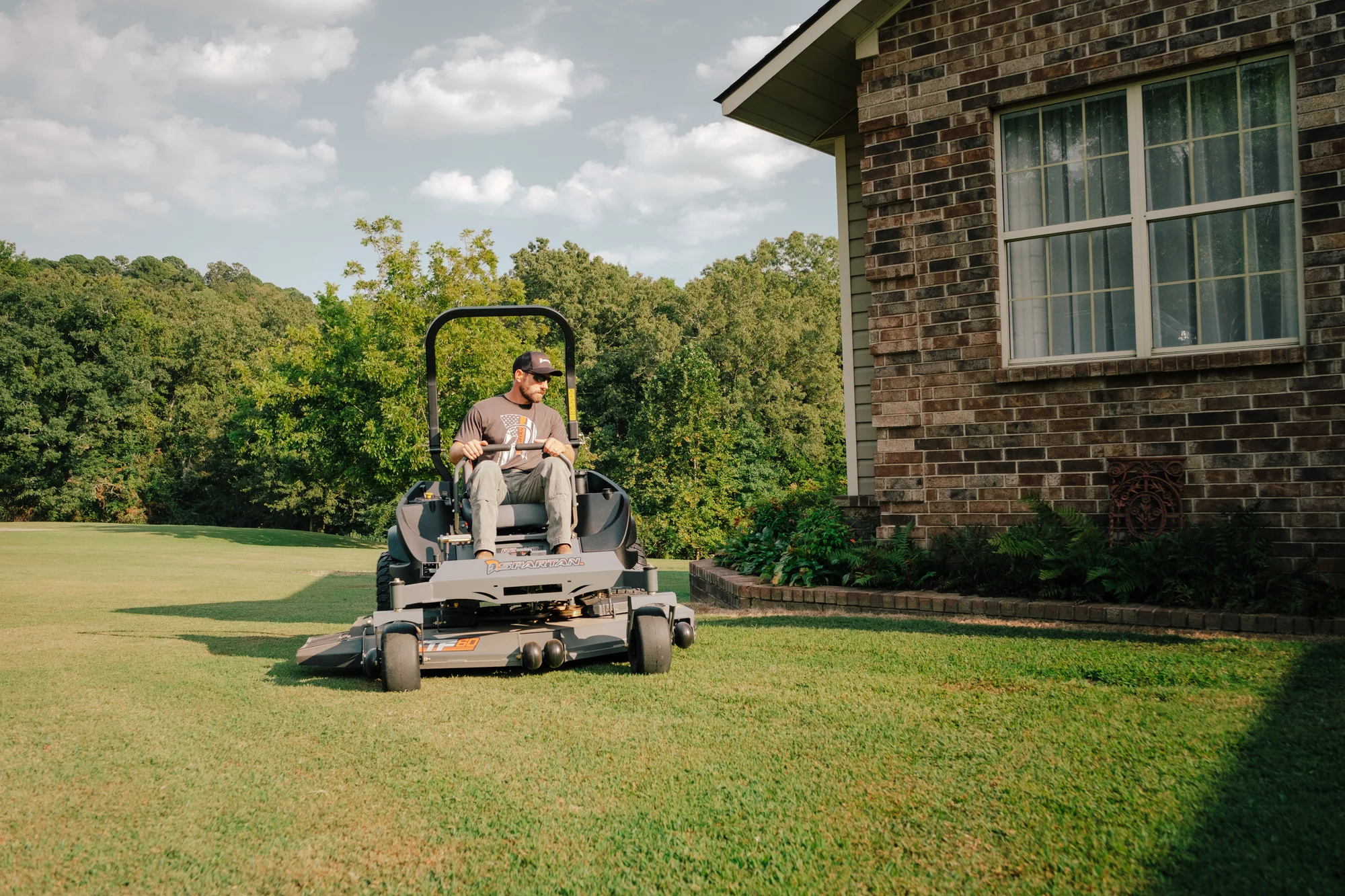 Spartan RZ-HD Zero Turn Rider RSZL1160FR730 Spartan Rz Hd Zero Turn Rider Rszl1160Fr730 Man Cutting Grass House Front View product image