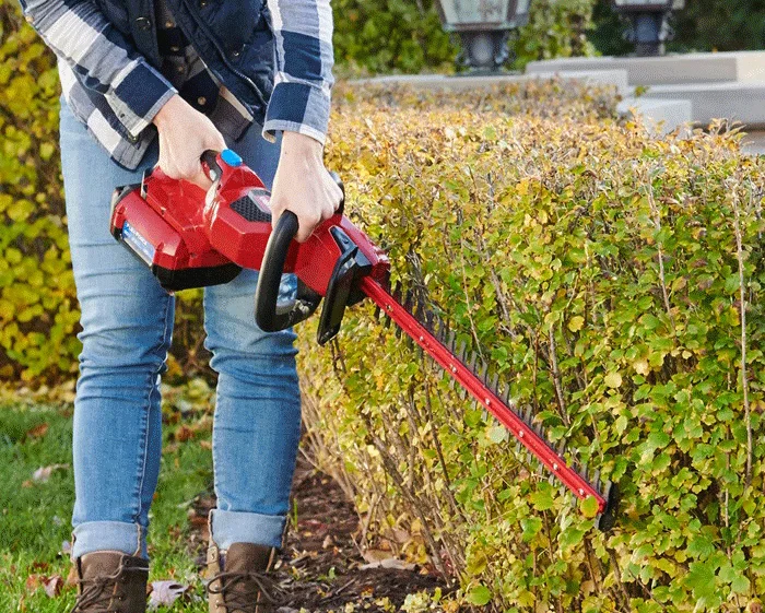Toro 60V Max Hedge Trimmer 51840 Woman Cutting Bushes Closeup product image