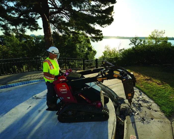 Toro Dingo Tx 750 Electric Wide Track Loader 22231 Man Breaking Concrete Side View product image