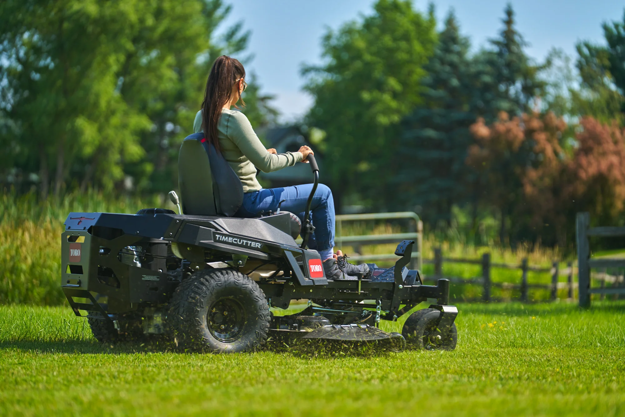 Toro Timecutter Max Havoc Myride Series Zero Turn Rider 77507 Woman Mowing Back View Wide Angle product image