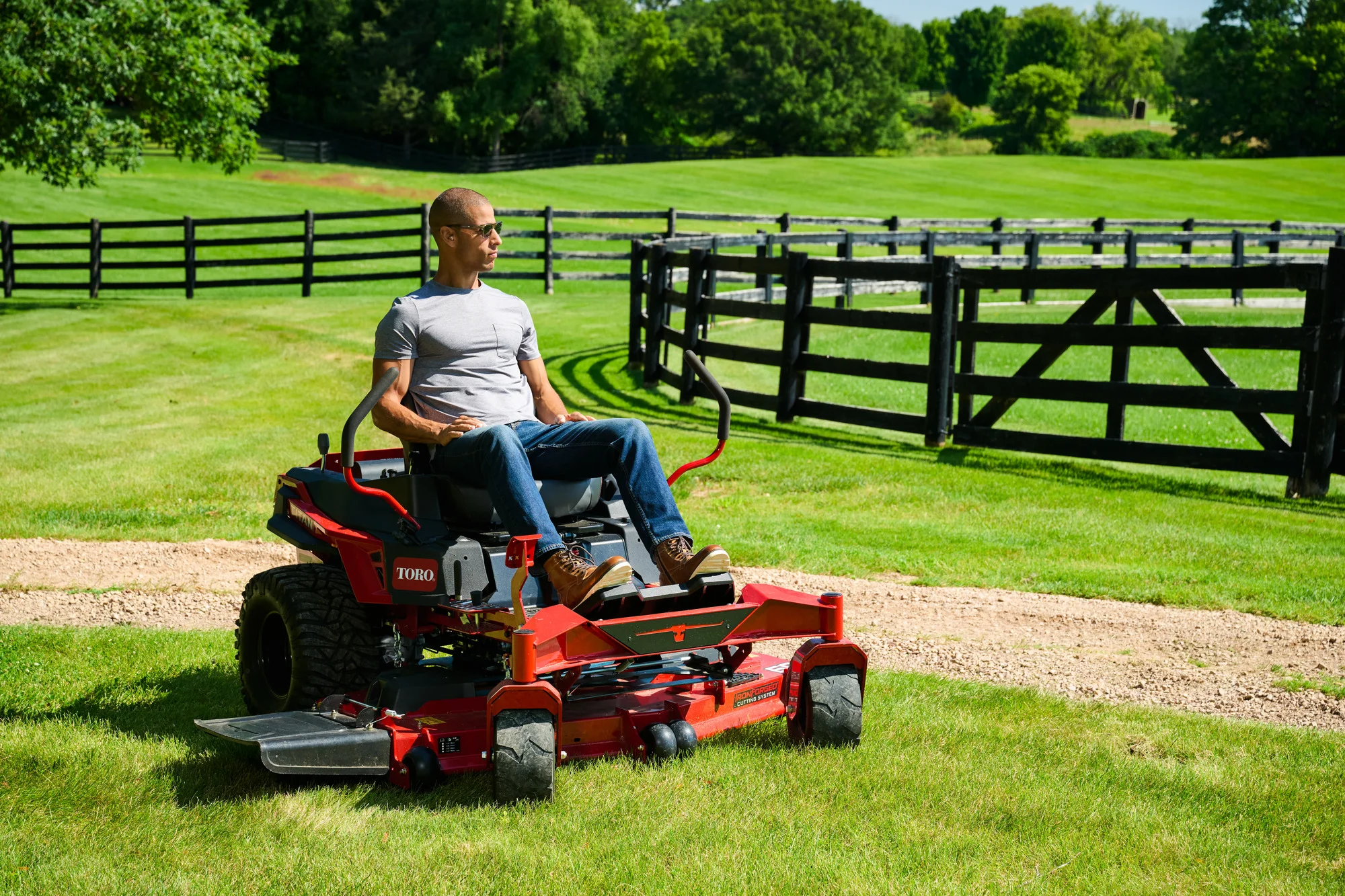 Toro Titan Series Zero Turn Rider 76614 Toro Titan Series 76614 Man Mowing Gated Fence product image